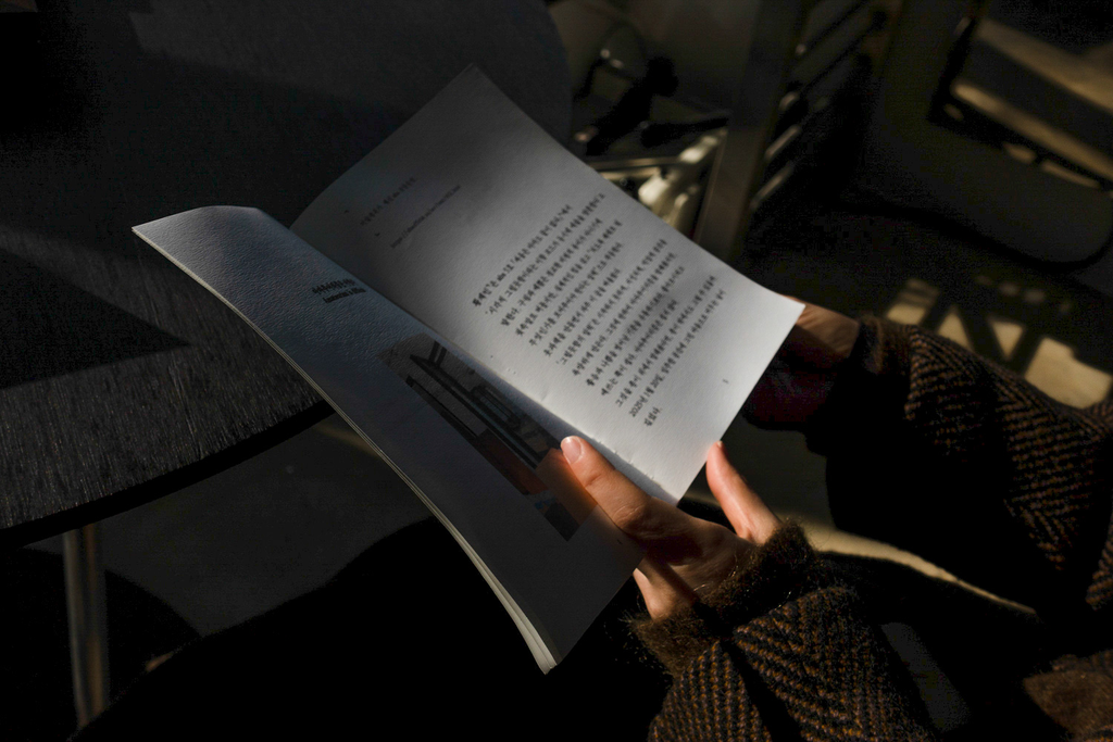 옷과책 레지던시 글이 담긴 책을 펼친 손