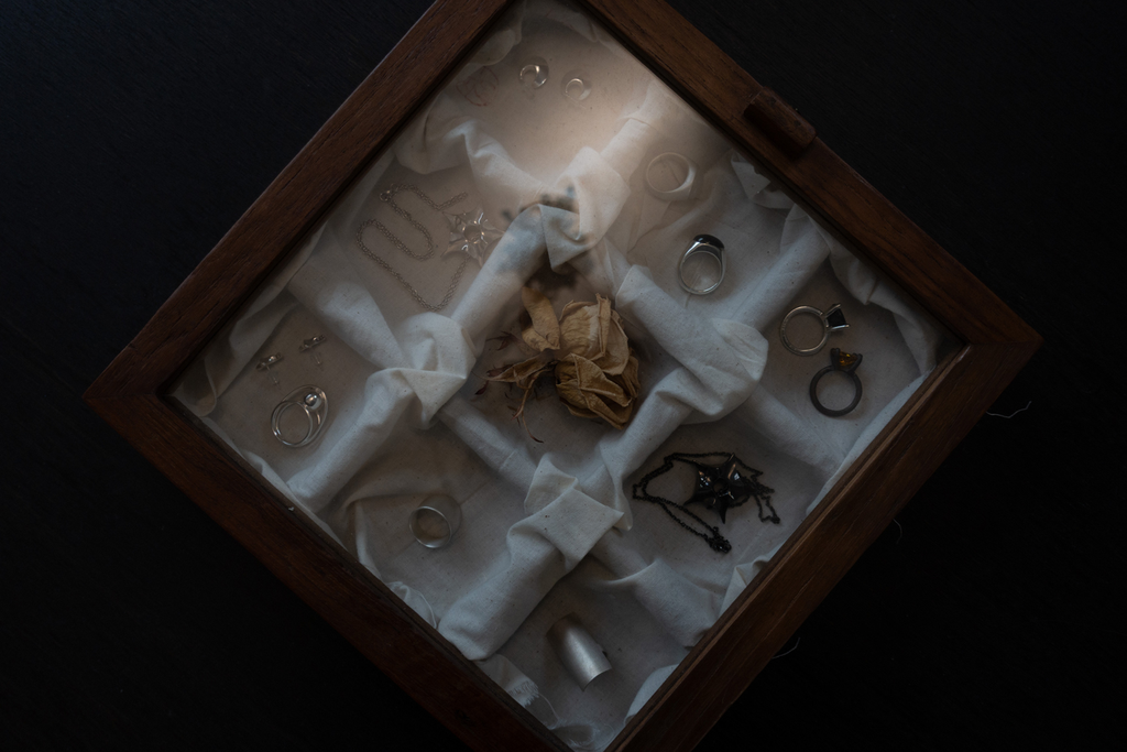 나무 진열함 속 실버 주얼리와 말린 장미